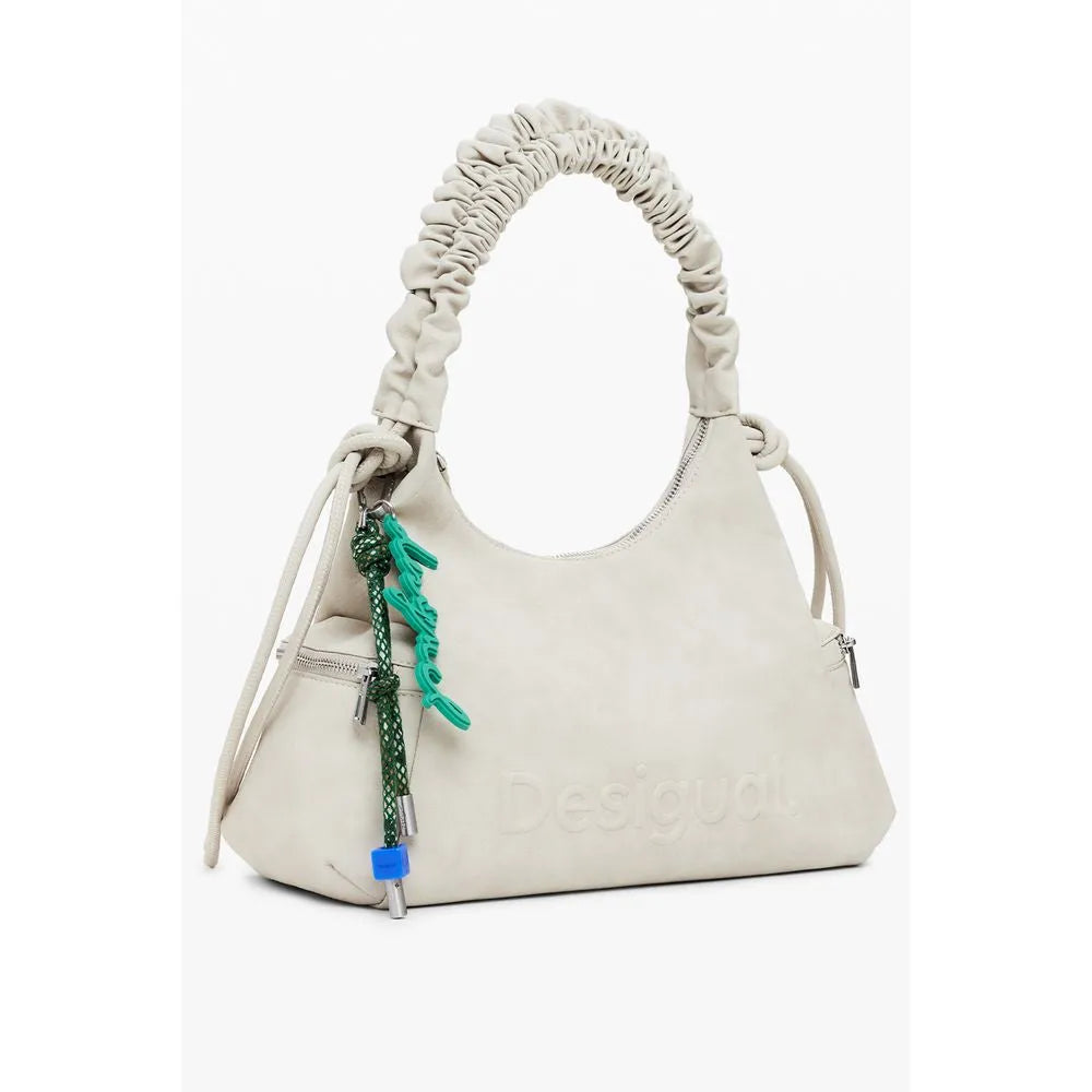 Beige Desigual Montville polyurethane women's handbag with a ruched shoulder handle, embossed logo, and green cord charm.
