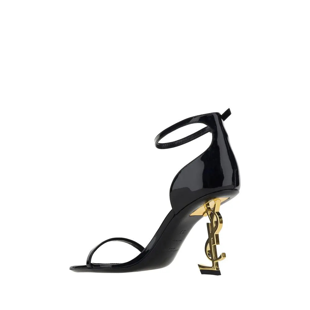 Black patent calf leather Saint Laurent Opyum sandals with a gold YSL logo sculptural heel and ankle strap.