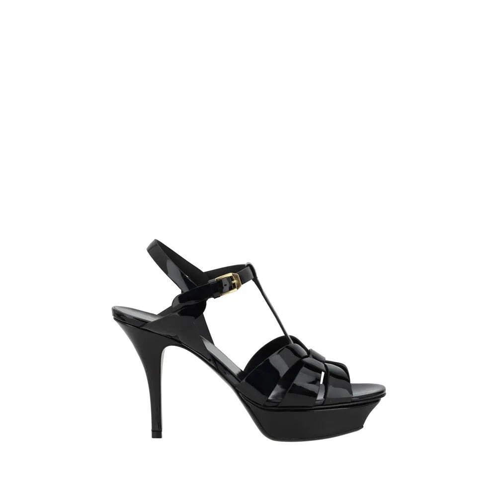 Black patent calf leather Saint Laurent Tribute platform stiletto sandals with caged toe and ankle strap.