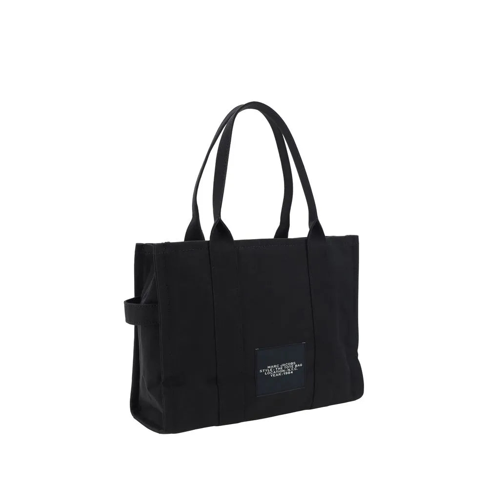 Black cotton Marc Jacobs The Large Tote Bag with top handles and front logo patch.