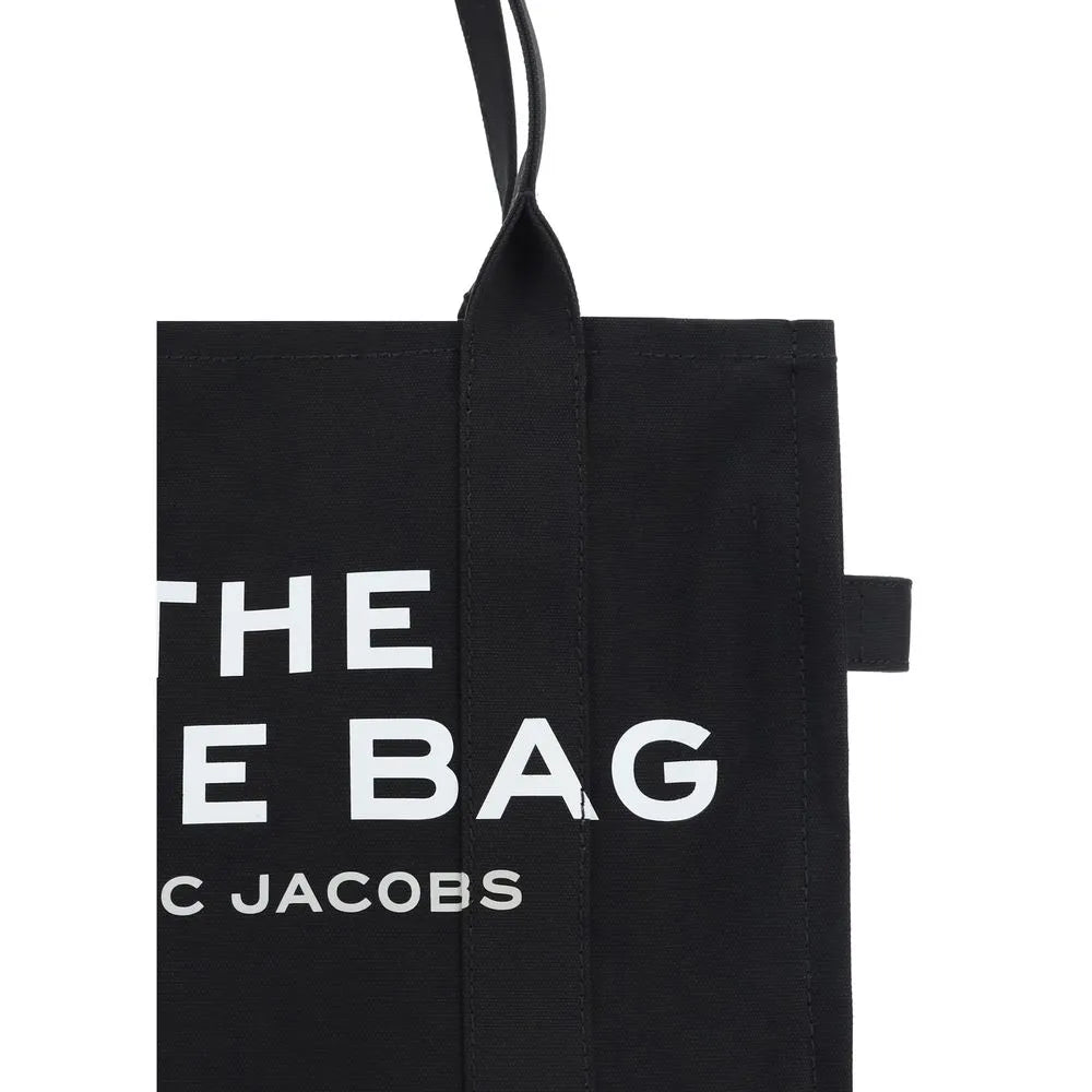 Black cotton canvas Marc Jacobs tote with large white "THE BAG" logo and top handle.