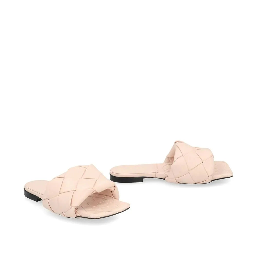 Nude woven leather flat sandals for women, featuring a square toe and black rubber sole.