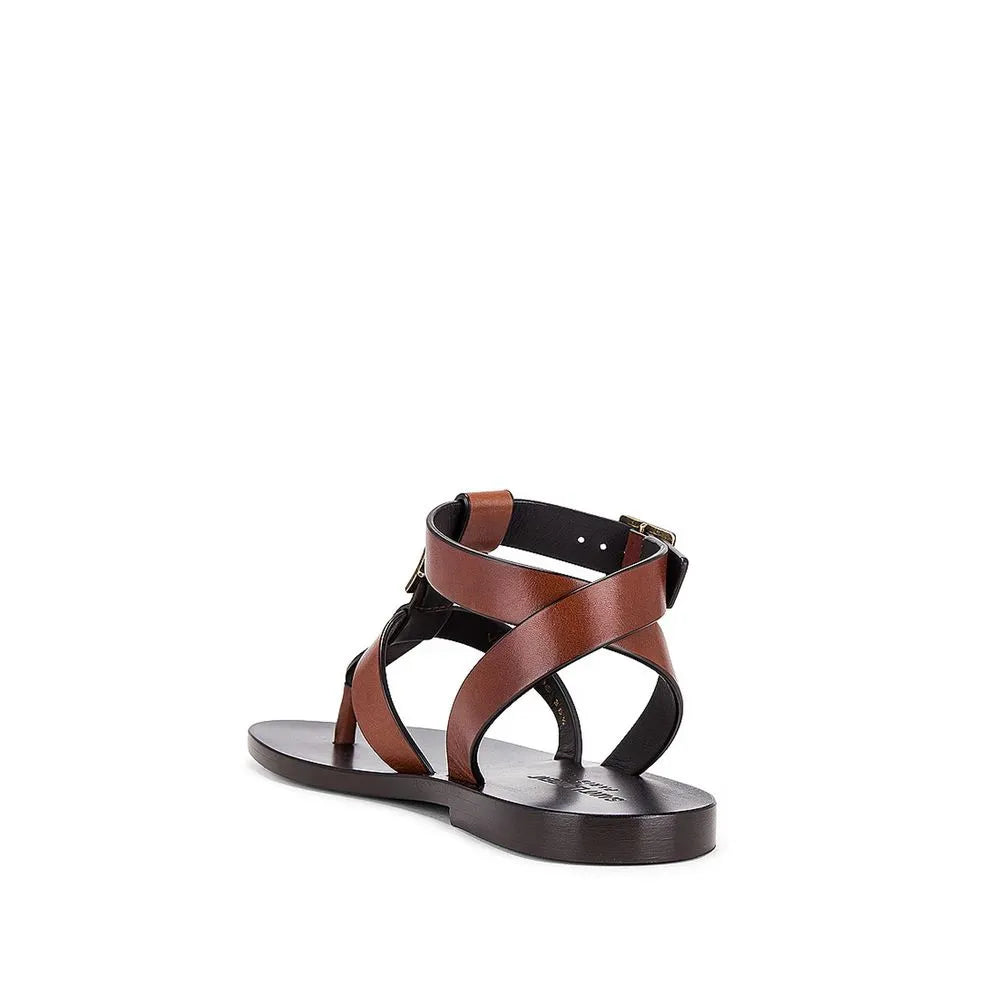 Women's brown calfskin flip-flop sandals with criss-cross ankle straps, brass buckles, and leather sole.