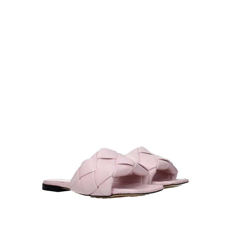 Blush pink woven calfskin flat slide sandals with a padded upper and square toe.