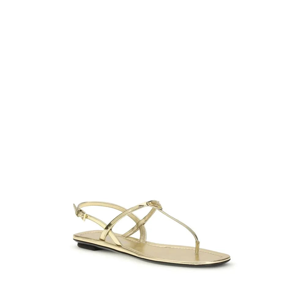 Shiny gold patent calf leather flat sandals with thin thong straps, adjustable ankle buckle, and subtle logo.