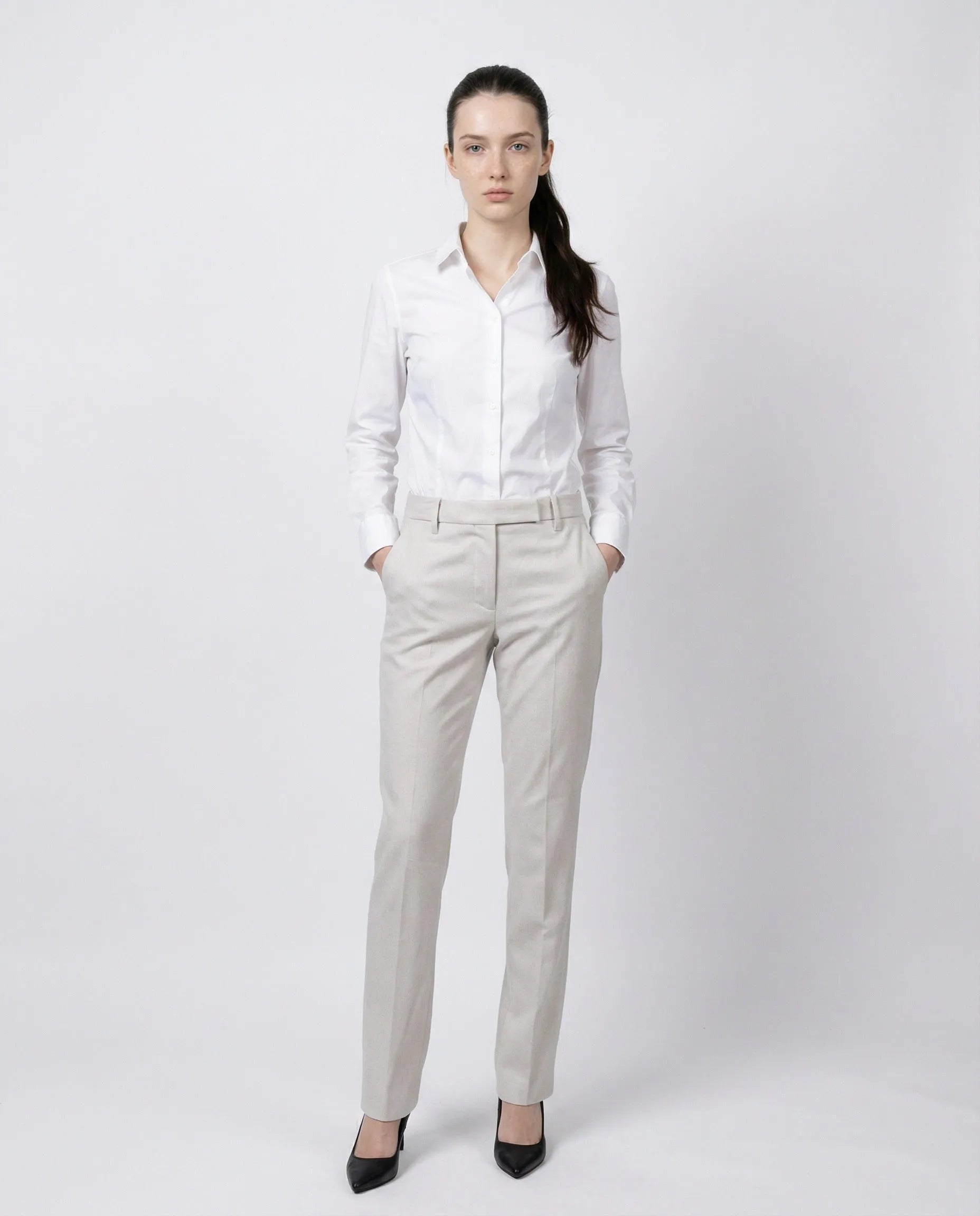 White cotton blend tailored pants with straight legs and front pockets, modeled by a woman.